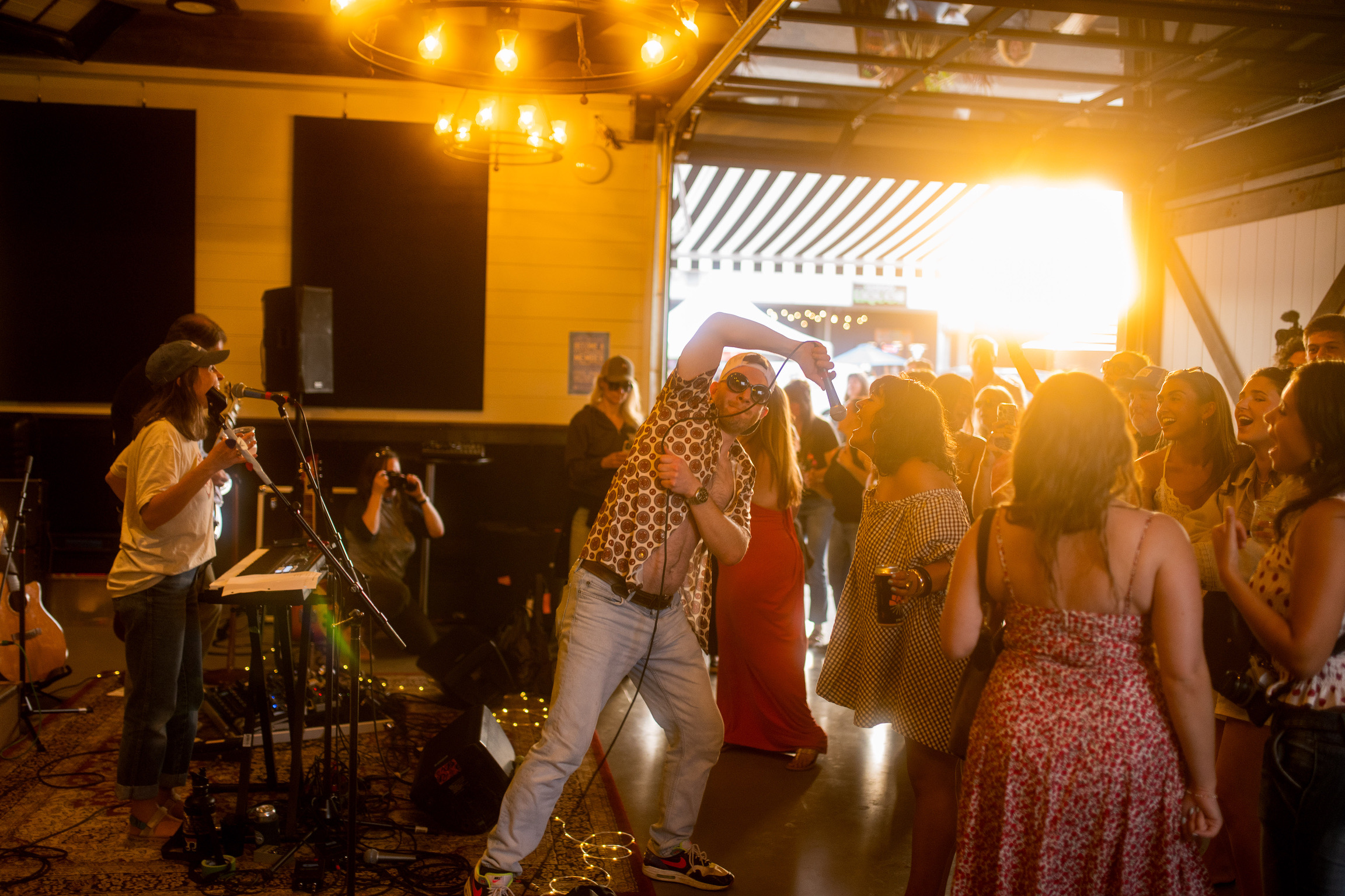 Singer performing for a crowd at golden hour